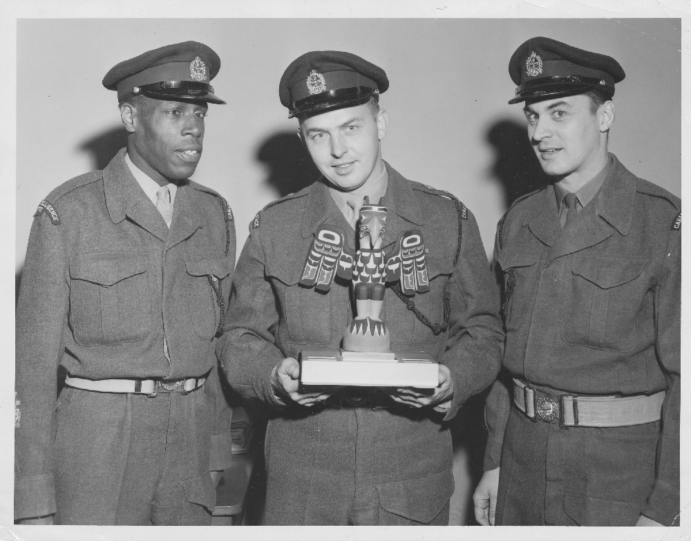 Three men in uniform posing with a trophy. Samuel Gaskin is on left. 