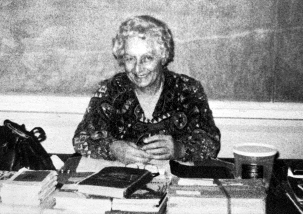 Teacher, Mrs Sylvia Weagle sitting at her desk 
