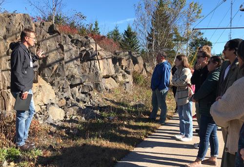 Image of Tim Fedak giving a presentation on geology outside.