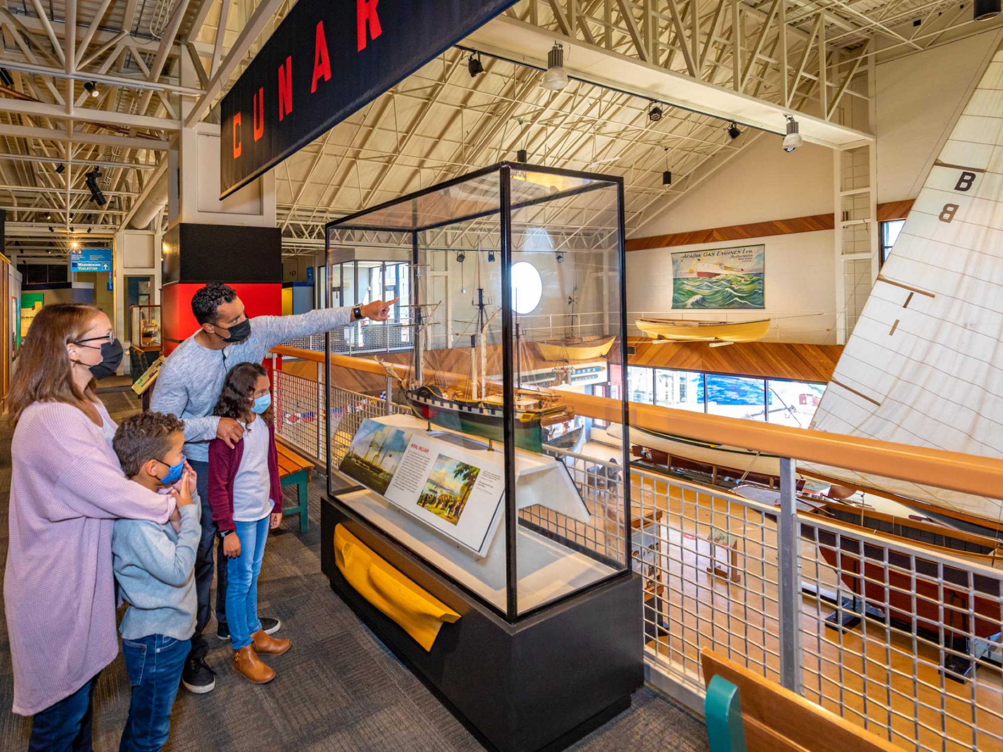Masked family looking at model ships at the Maritime Museum of the Atlantic.