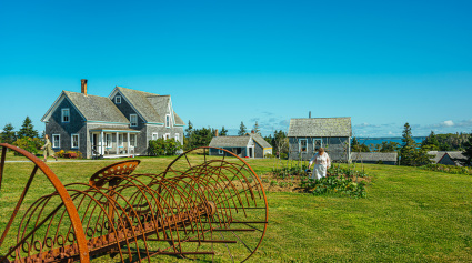 A field with farm equipment and home in the background.