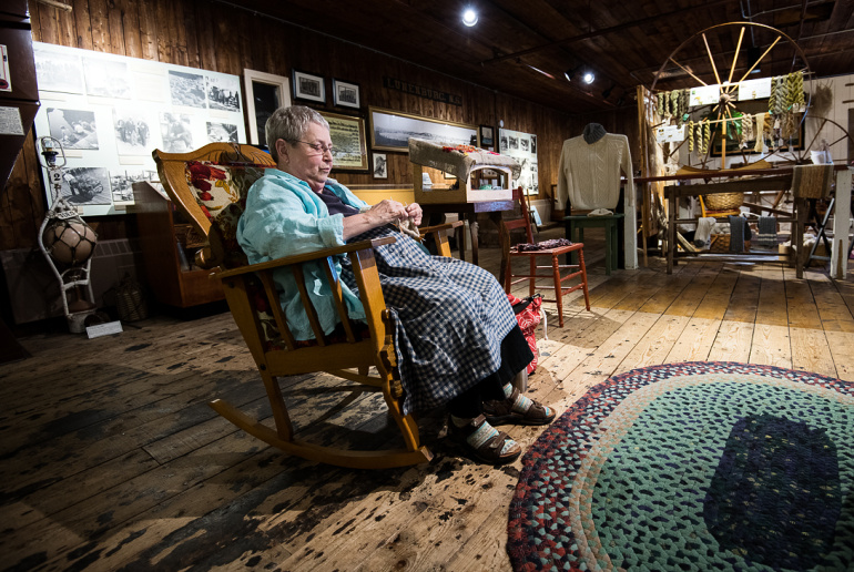 Fisheries Museum of the Atlantic interpreter knitting in a rocking chair.