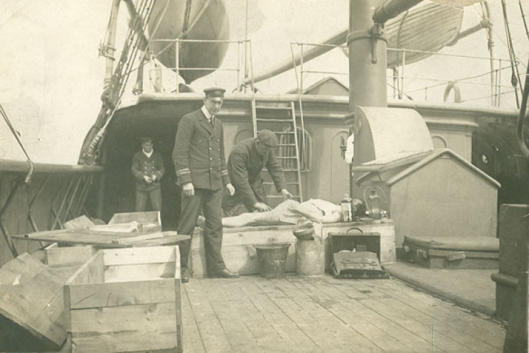 A Titanic victim is embalmed aboard the cable ship Minia.