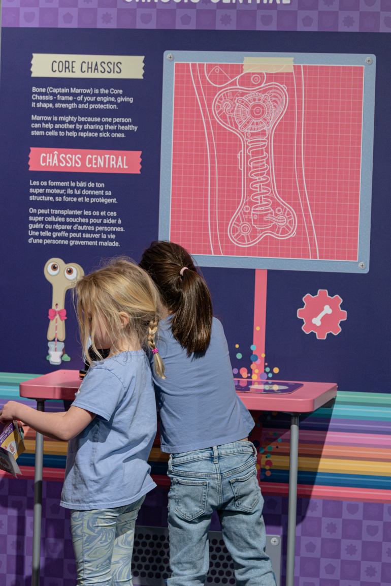 Girls explore an interactive station in the Mighty Engine exhibit.