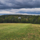 Uniacke Estate in the distance, a grand white house with a classical design, including a columned entrance and a long veranda. The house is surrounded by a well-maintained lawn and mature trees.