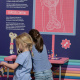 Girls explore an interactive station in the Mighty Engine exhibit.