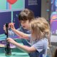 Two children collecting stamps in the Mighty Engine exhibit.