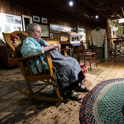 Fisheries Museum of the Atlantic interpreter knitting in a rocking chair.