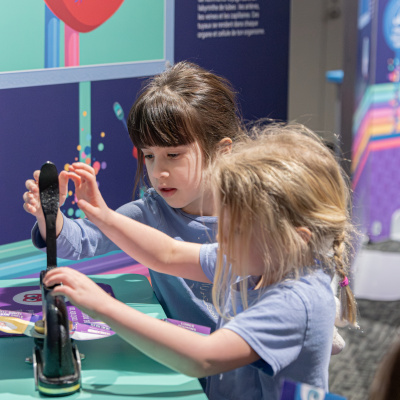 Two children collecting stamps in the Mighty Engine exhibit.