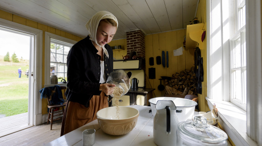 Female costumed interpreter working in kitchen at Baile nan Gàidheal | Highland Village.