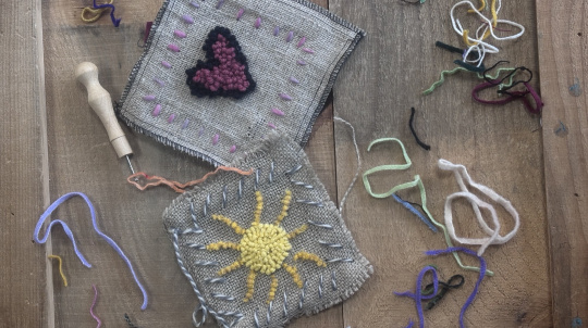 Rug hooking of a sun and a heart.